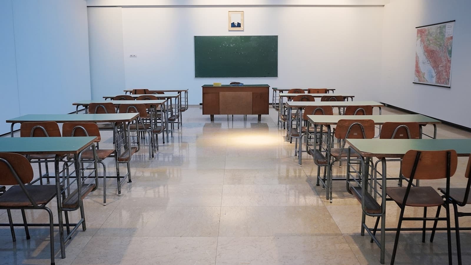 Leerer Klassenraum mit Tafel und Schreibtischen