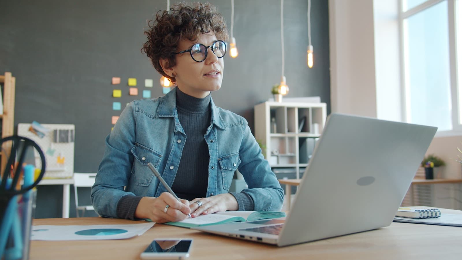 Frau beim Planen und Schreiben an einem Laptop